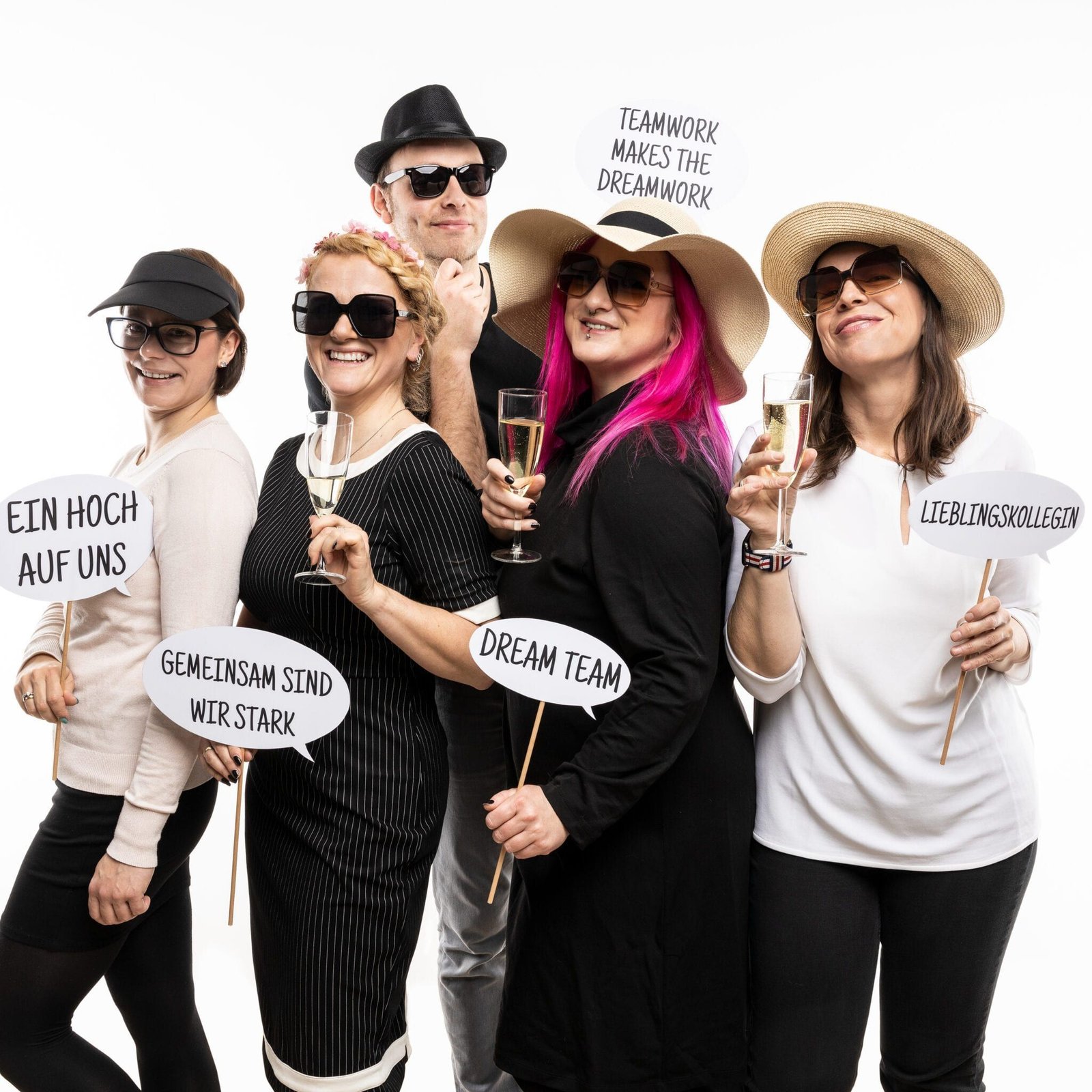 Kolleginnen und Kollegen posieren mit Requisiten vor der Fotobox